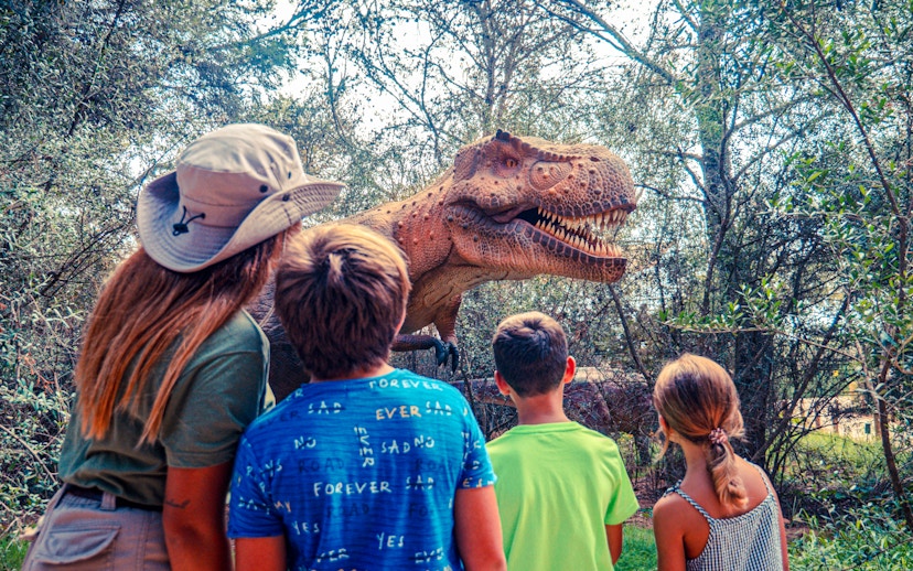 Guests observing a dinosaur exhibit at Dinosaurland, Mallorca.