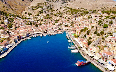 Aerial view of Symi harbor with colorful buildings and boats, Rhodes.