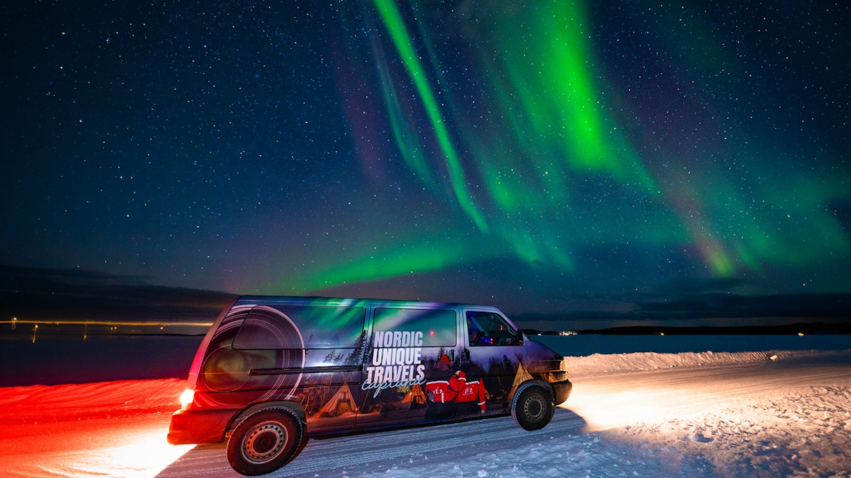 Van under Northern Lights in Rovaniemi during small-group photography tour.