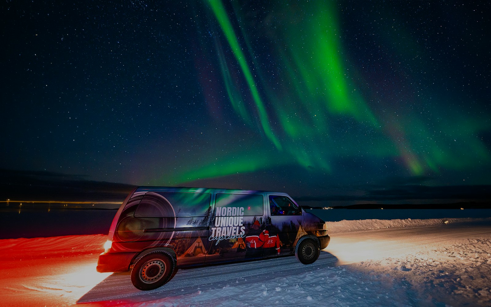 Van under Northern Lights in Rovaniemi during small-group photography tour.