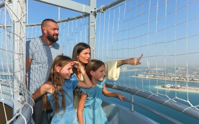 Family enjoying the view from The Dubai Balloon at Atlantis, overlooking the city skyline.