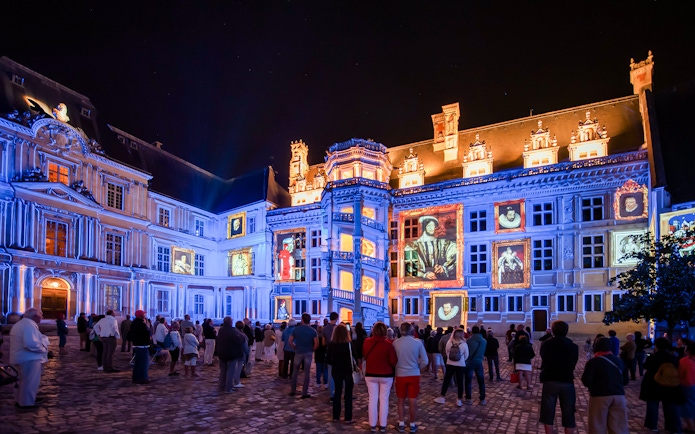 Visitors watching Sound and Light Show at Royal Château of Blois, France.
