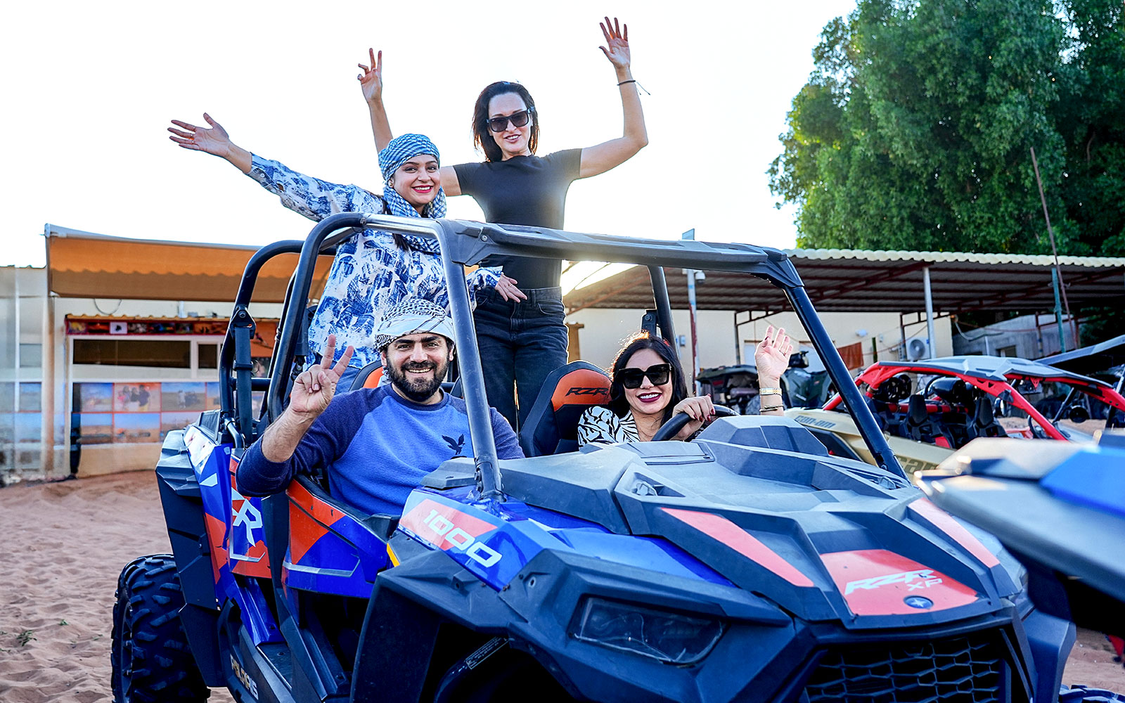 People enjoying dune bashing in a desert safari with off-road vehicles.
