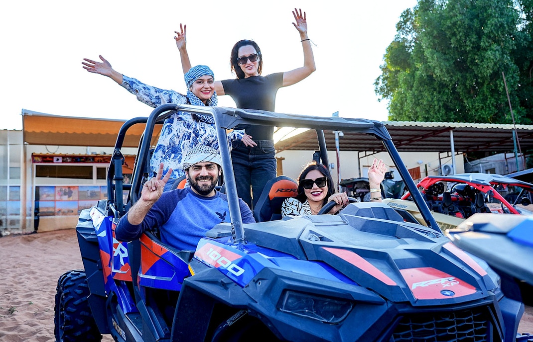People enjoying dune bashing during an evening desert safari in Dubai.