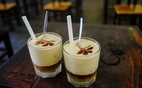 Vietnamese egg coffee on a wooden table during Hanoi Walking Street Food Tour.