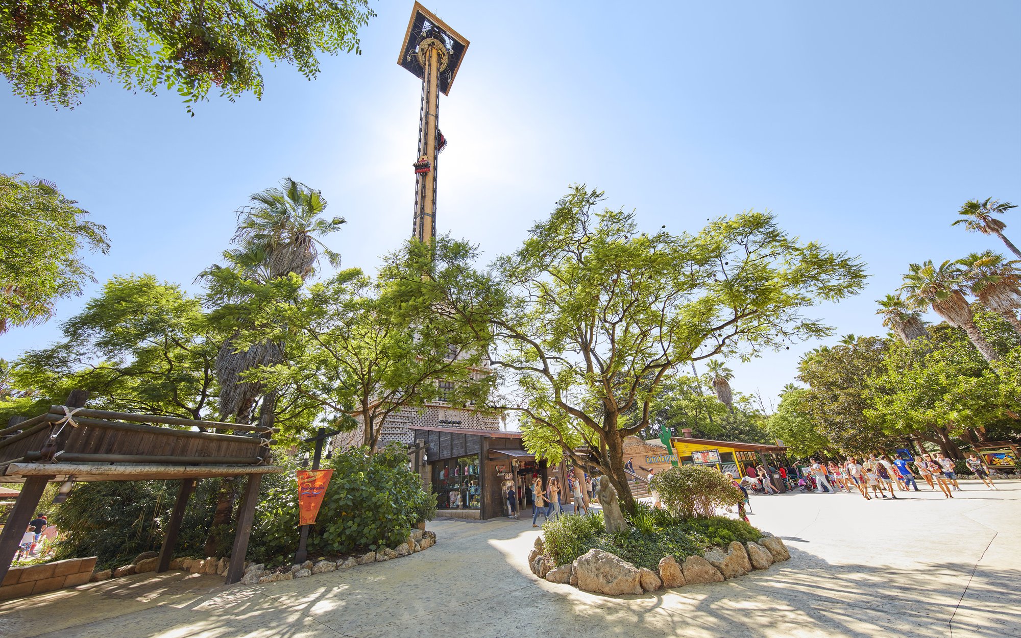 Hurakan Condor ride at PortAventura surrounded by trees and visitors.