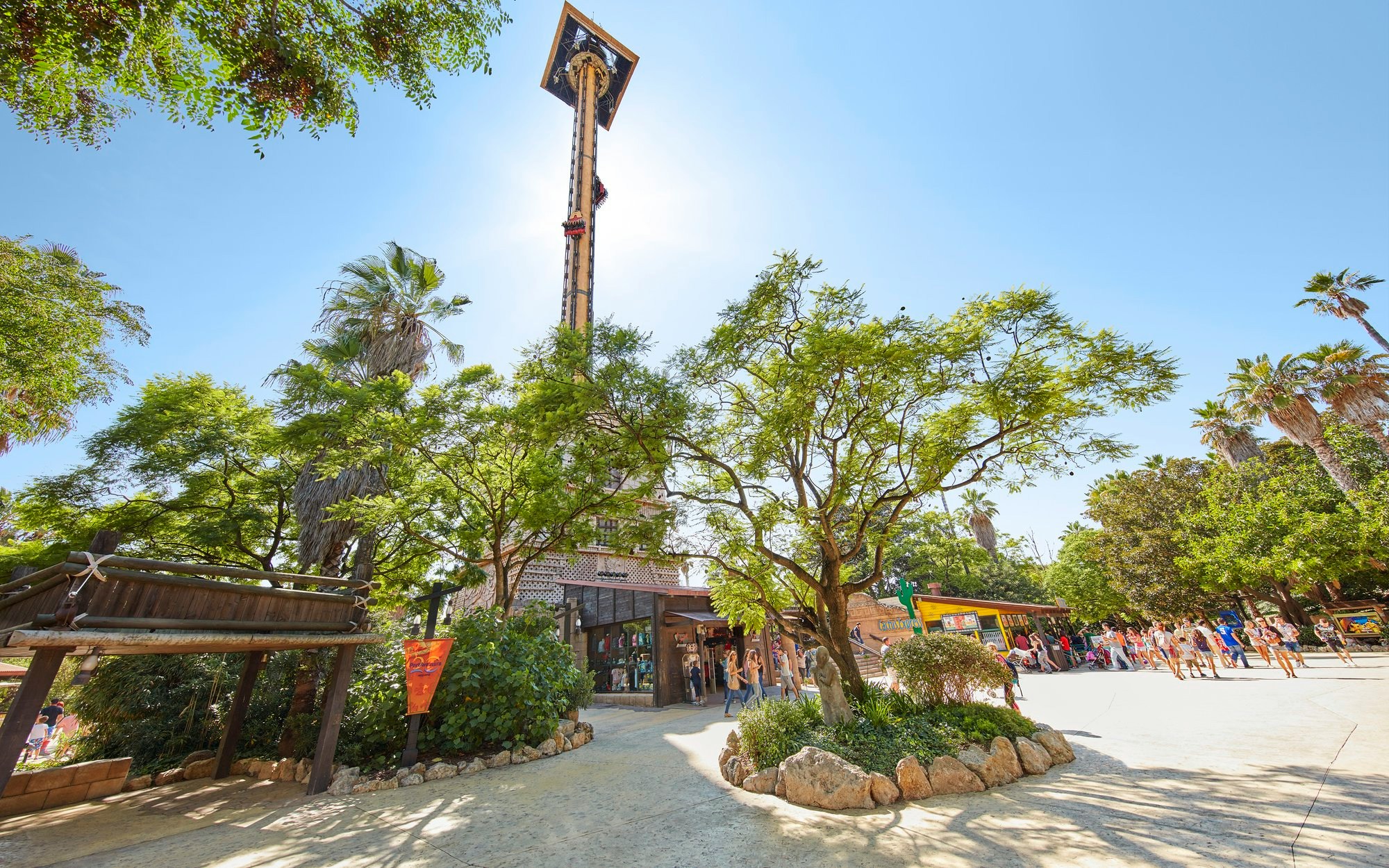 Hurakan Condor ride at PortAventura surrounded by trees and visitors.