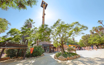 Hurakan Condor ride at PortAventura surrounded by trees and visitors.