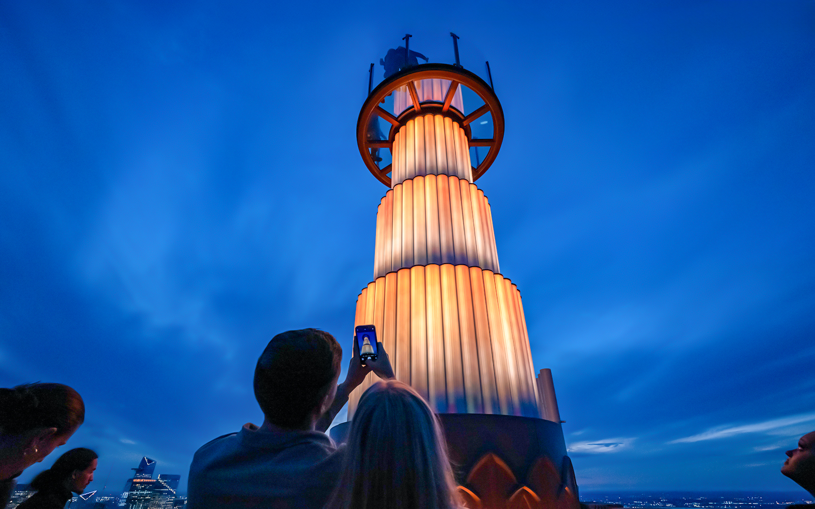 Visitors photographing the illuminated tower at Top of the Rock Observation Deck, New York City.