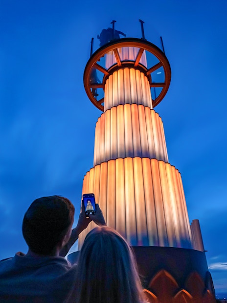 Visitors photographing the illuminated tower at Top of the Rock Observation Deck, New York City.