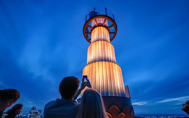 Visitors photographing the illuminated tower at Top of the Rock Observation Deck, New York City.