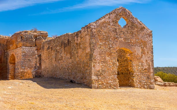 Ancient stone ruins in Algarve under a clear blue sky.