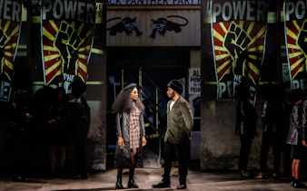 Stage performance of "I'm Every Woman" in Westend with actors in front of Black Panther Party backdrop.