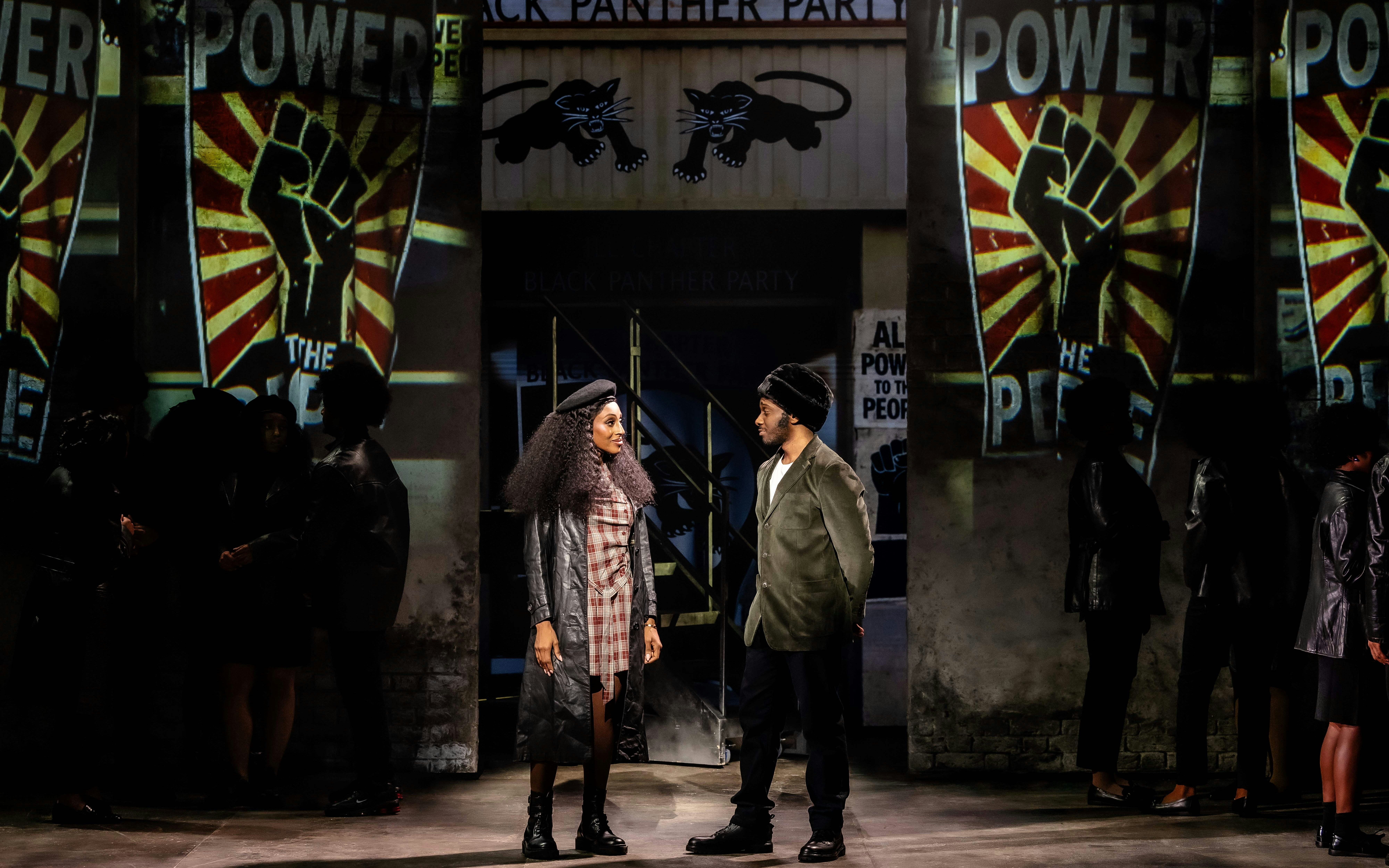 Stage performance of "I'm Every Woman" in Westend with actors in front of Black Panther Party backdrop.