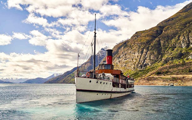 TSS Earnslaw steamboat cruising on Lake Wakatipu with mountain backdrop, Queenstown.