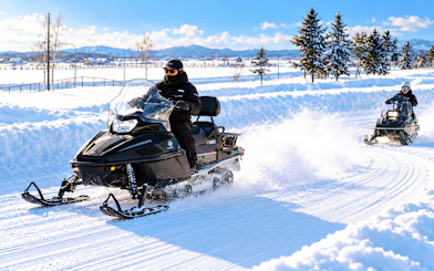 Snowmobiling on a snowy trail during Sapporo to Bibai Snow Land tour, Hokkaido.