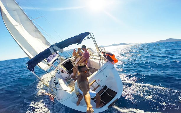 Sailboat with people enjoying excursion to Asinara National Park from Stintino.