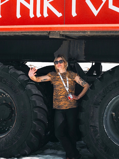 Red Monster truck on Langjökull Glacier Tour from Gullfoss with a person standing beside it.