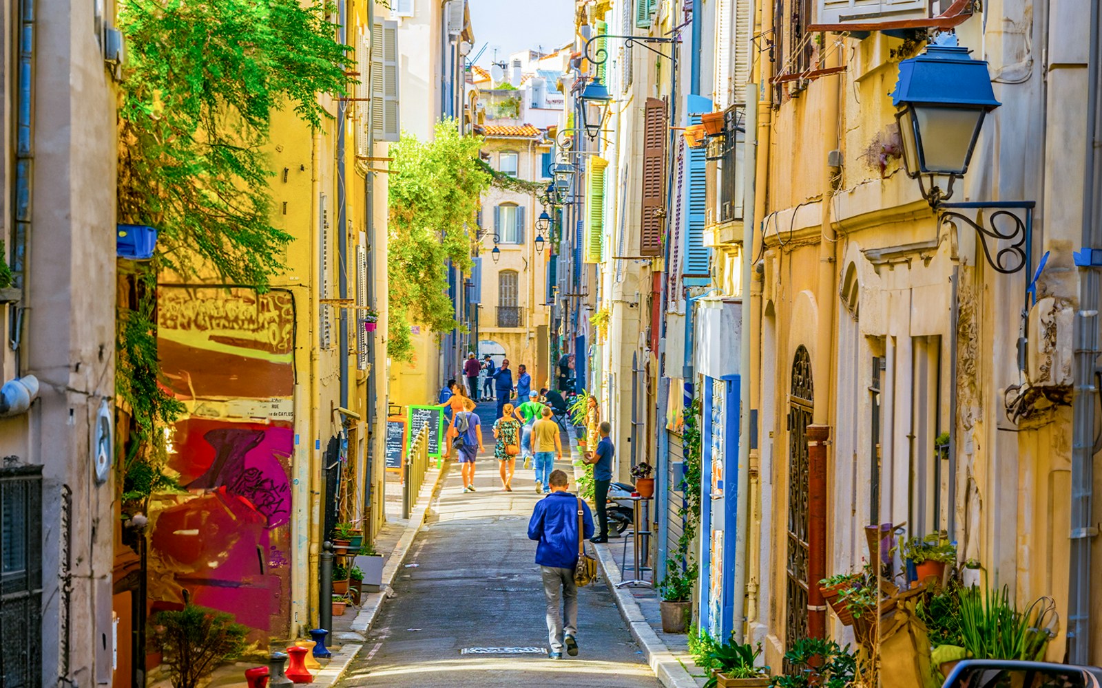 Le Panier street in Marseille with colorful buildings and people walking.