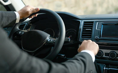 Chauffeur driving a luxury vehicle for professional transfers.