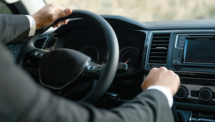 Chauffeur driving a luxury vehicle for professional transfers.