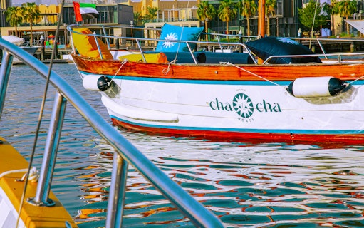Boat docked in Jumeirah marina with UAE flag, part of Jumeirah Swimming Tour.