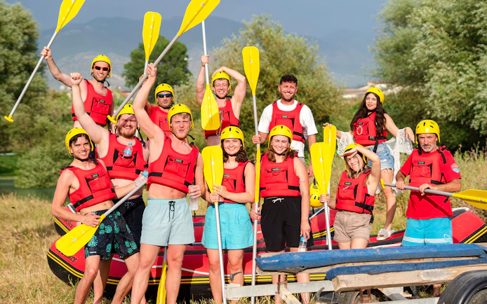 Group preparing for Bistrice River rafting adventure near Saranda, holding paddles and wearing safety gear.