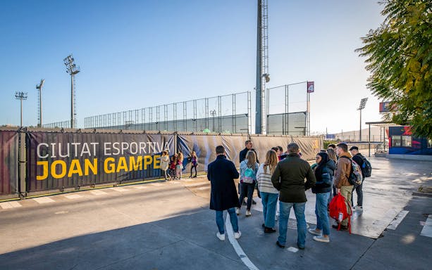Visitors gather at Ciutat Esportiva Joan Gamper entrance during Barça Museum tour.