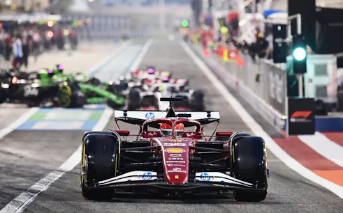 Formula 1 cars racing at Bahrain Grand Prix track.