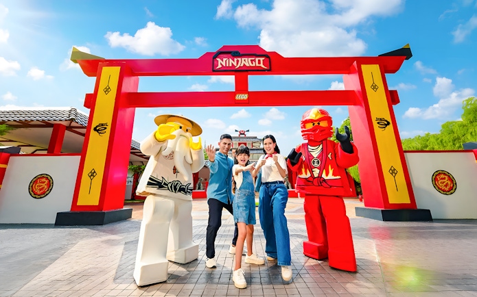 Family posing with Lego Ninjago figures at LEGOLAND Malaysia Theme Park.