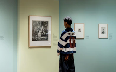 Visitor viewing Rembrandt etchings at Rembrandt House Museum exhibition.