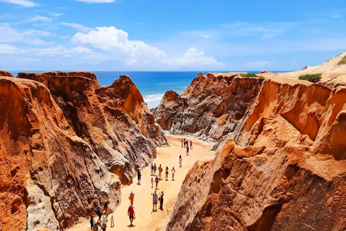 Visitors walking through colorful cliffs at Canoa Quebrada, East Coast, Brazil.