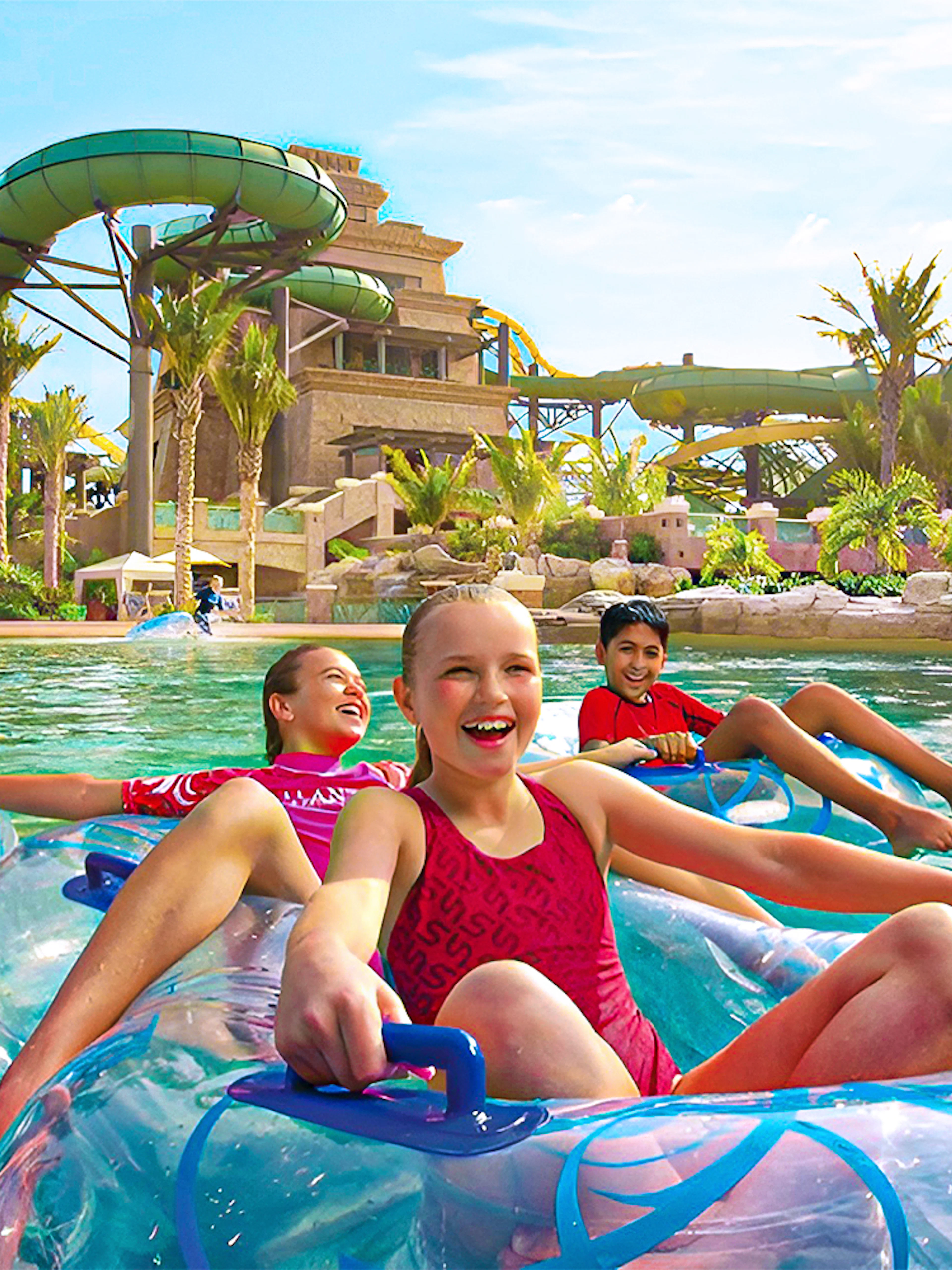 Tourists enjoying water slides at Aquaventure Waterpark, Dubai, with Lost Chambers Aquarium combo tickets.