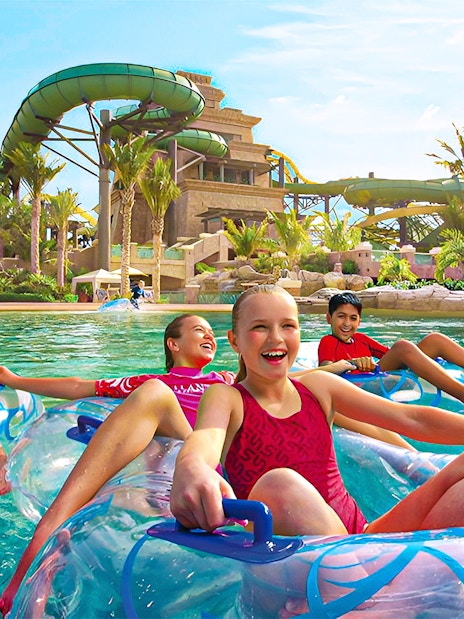 Tourists enjoying water slides at Aquaventure Waterpark, Dubai, with Lost Chambers Aquarium combo tickets.