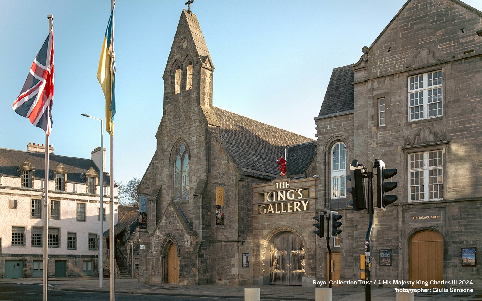 King's Gallery entrance at Palace of Holyroodhouse, Edinburgh, with flags and historic architecture.