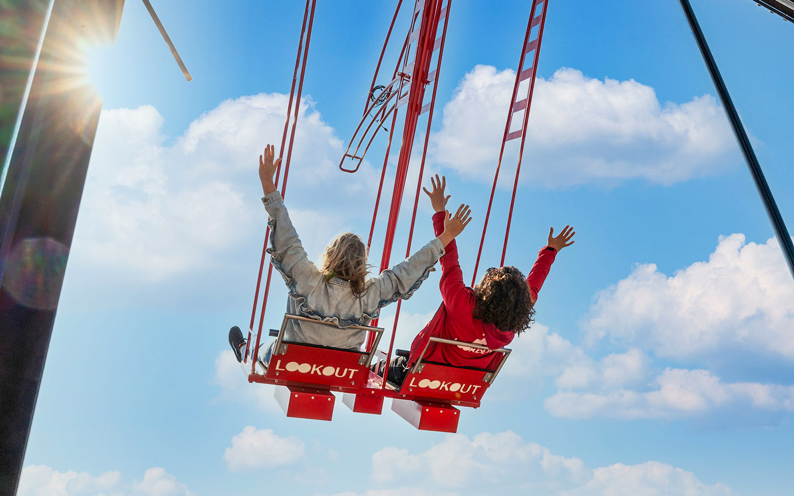 Visitors enjoying the swing at ADAM Lookout Over the Edge in Amsterdam with city skyline views.