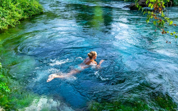 Tourist swimming in the Blue Eye waters, Albania.