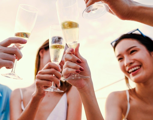 People toasting with sparkling wine on a sundowner cruise.