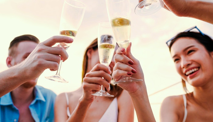 People toasting with sparkling wine on a sundowner cruise.
