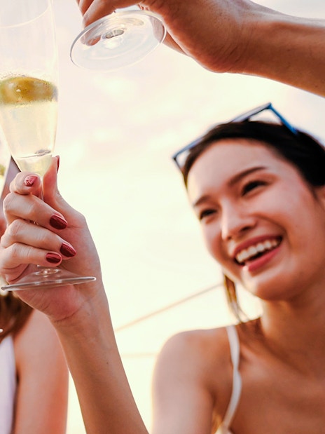 People toasting with sparkling wine on a sundowner cruise.
