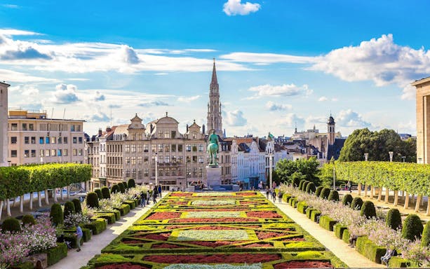Mont des Arts garden with colorful flower beds and Brussels skyline in Belgium.