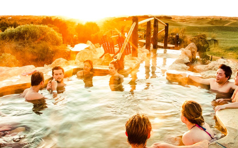 People relaxing in a hot spring at sunset on Mornington Peninsula.