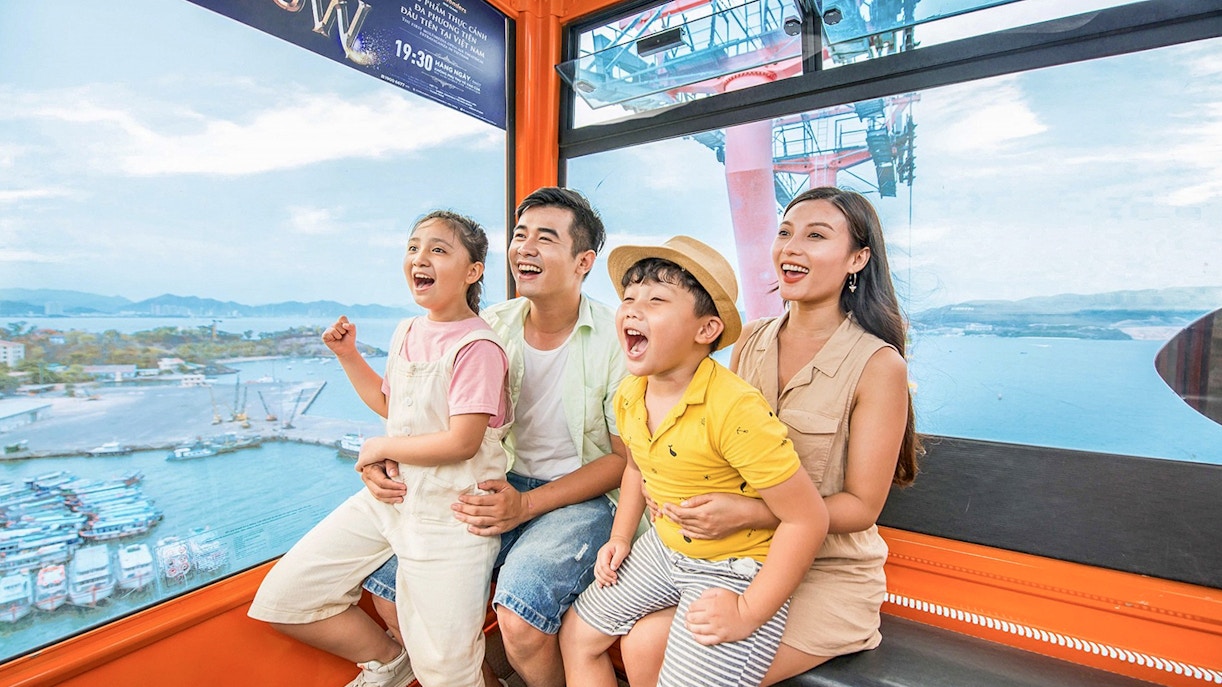 Family enjoying a cable car ride at Vinwonders, Nha Trang, Vietnam with ocean view.