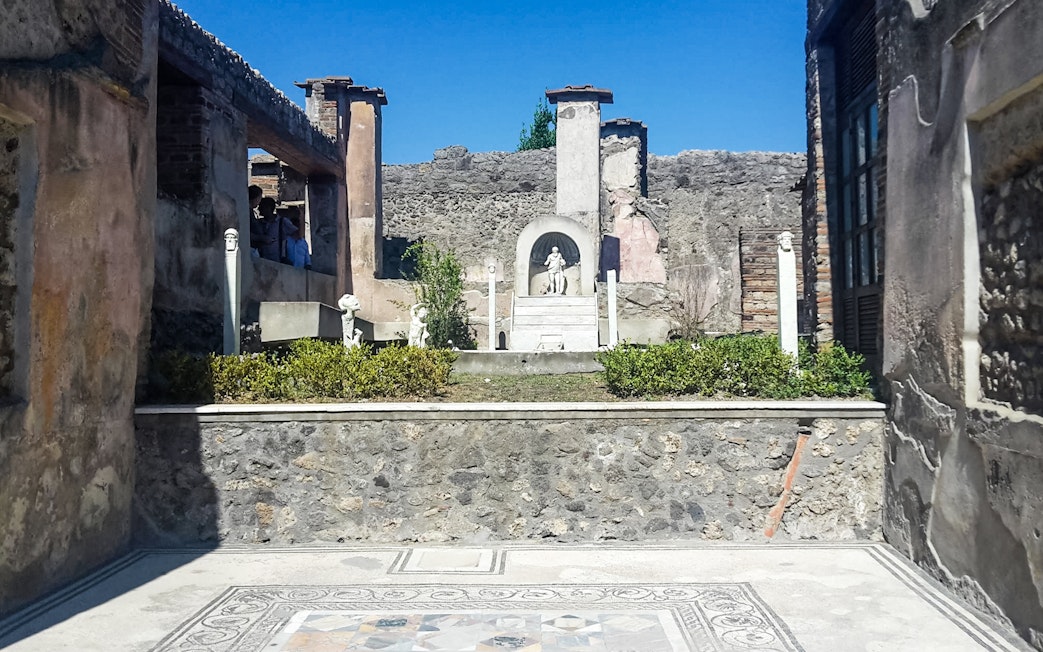 Pompeii ruins with ancient statues and stone walls in Italy.