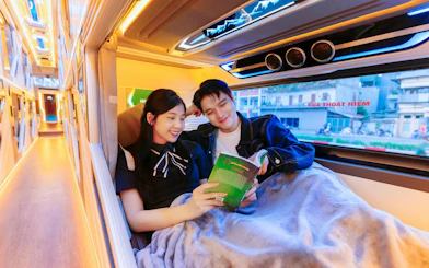 Couple relaxing in a sleeper cabin during Sapa–Hanoi–Noi Bai Airport shuttle transfer.