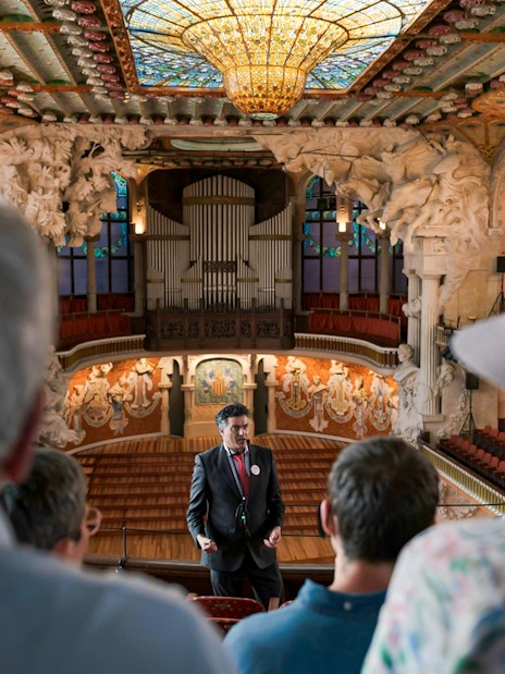 Tour guide speaking to visitors inside Palau de la Música Catalana, Barcelona.