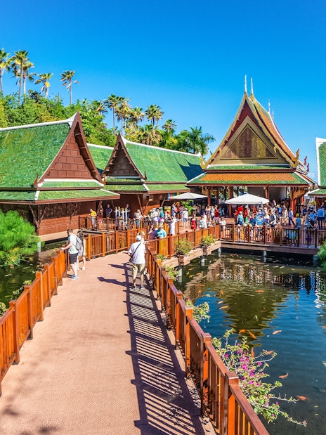 Visitors on a bridge at Loro Park, Tenerife, with traditional Thai architecture and koi pond.