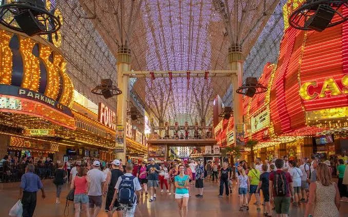 Downtown Las Vegas Fremont Street with crowds, neon lights, and casino signs.
