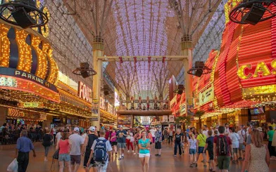 Downtown Las Vegas Fremont Street with crowds, neon lights, and casino signs.