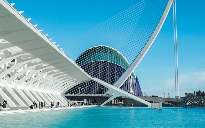 Hemisfèric architecture at City of Arts and Sciences, Valencia, with blue sky and water.